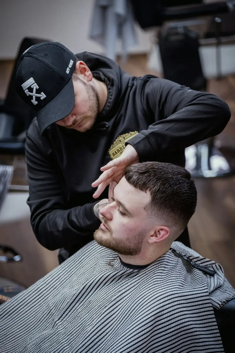 Barbeiro aparando a barba de um cliente